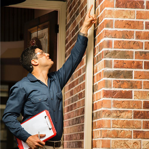 Building inspector inspecting the outside of a house.